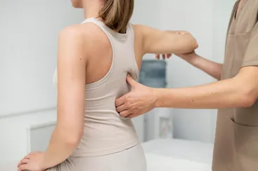 Terapeuta aplicando técnica de osteopatía estructural en la espalda de un paciente adulto